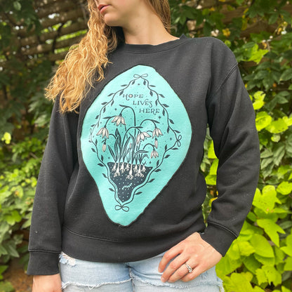 Hope Lives Here | Snow Drops | January Birth Flower | Black Sweater | Medium