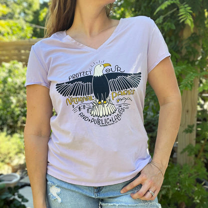 Person wearing a white t-shirt with an eagle graphic and text outdoors. Protect Our National Parks. hand-pulled screenprinted illustration on thrifted apparel, handmade, upcycled apparel
