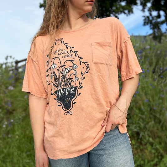 Hope Lives Here | Snow Drops | January Birth Flower | Orange Oversized Tee l Medium